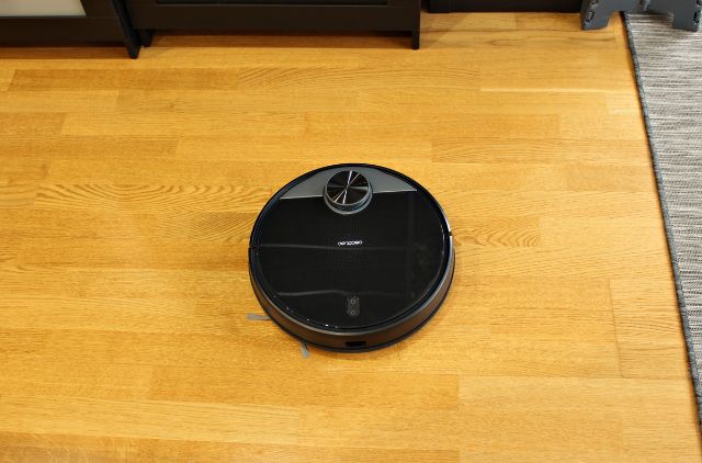 床の上に黒いロボット掃除機